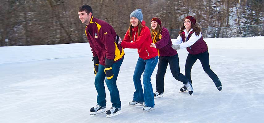 Students skating outside on an ice rink.