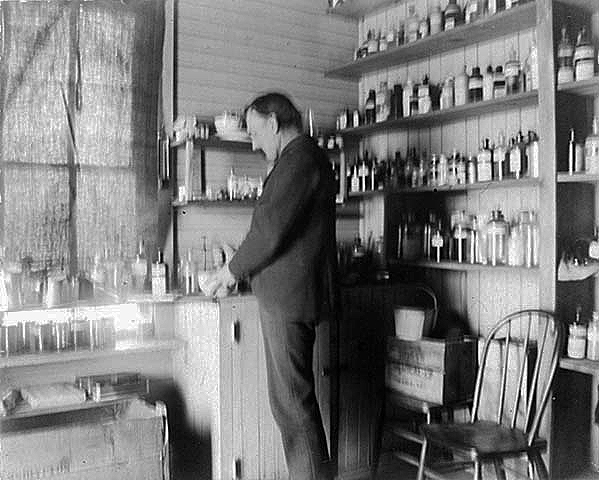 Man in a medical supply room at an Indian boarding school, location unknown, ca. 1900.