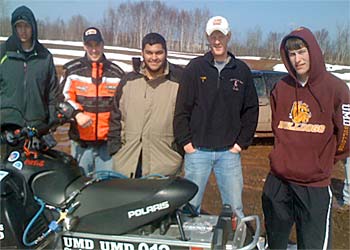 Students with clean snowmobile.