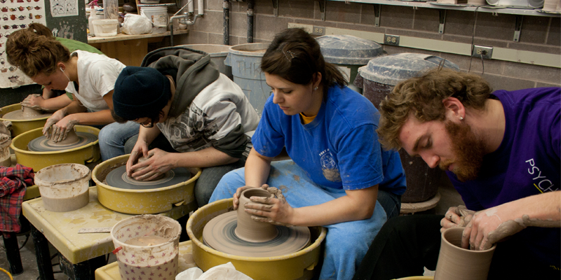 UMD students spinning pottery wheels