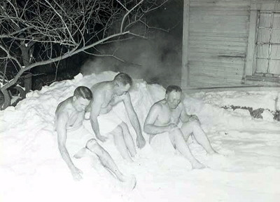 Three men cooling off in the snow after being in a sauna on Jacob Hoikka's farm near Annandale, 1960.