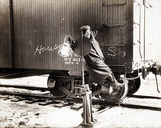 Northern Pacific switchman or brakeman giving switching signal with lighted lantern, ca. 1915.