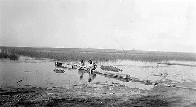 Indian girls washing clothes in lake, Nett Lake Indian Reservation, ca. 1930.