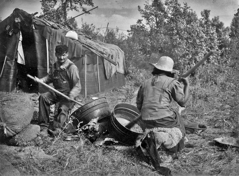 Paul Buffalo and wife parching wild rice at their camp, 1937.