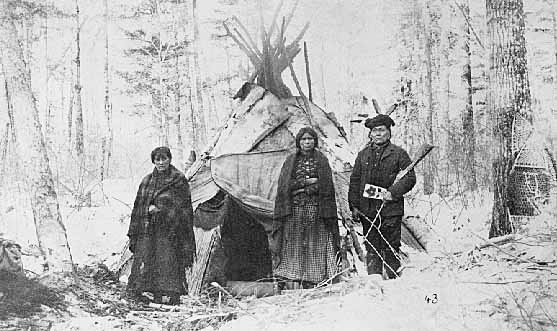 Chippewa family beside bark tepee.
