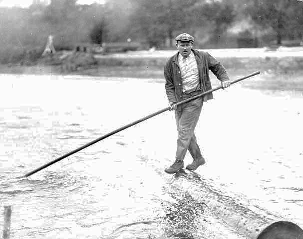 Man log rolling with pole, ca, 1925.