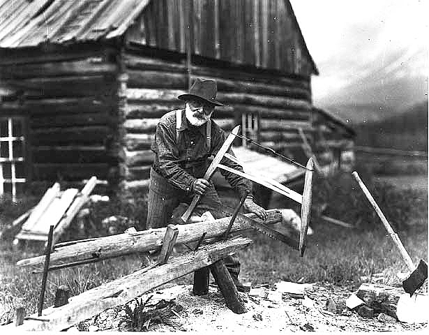 Man sawing wood, ca. 1915.