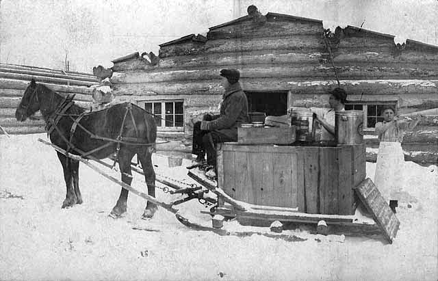 Loading sled with lumberjacks' lunch, ca. 1910.