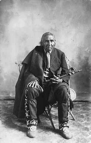 Elderly Indian man holding pipe, ca. 1910.