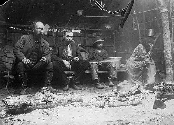 Waiting inside birch bark house for muskrat dinner, Cut Foot Sioux Lake, 1900.