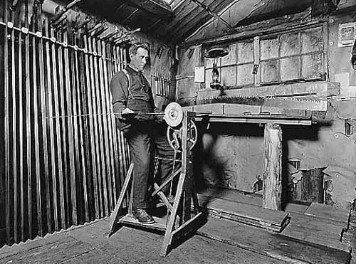 Man sharpening saw at Kileen & Company lumber camp, 1914.