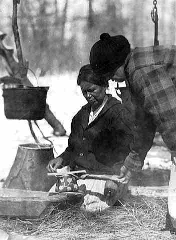 Ojibway women filling birch bark containers with maple sugar and syrup, Mille Lacs, ca. 1925.