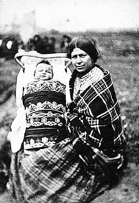 Chippewa woman and child in cradleboard, ca. 1885.