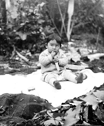 Baby seated on blanket, ca. 1920.