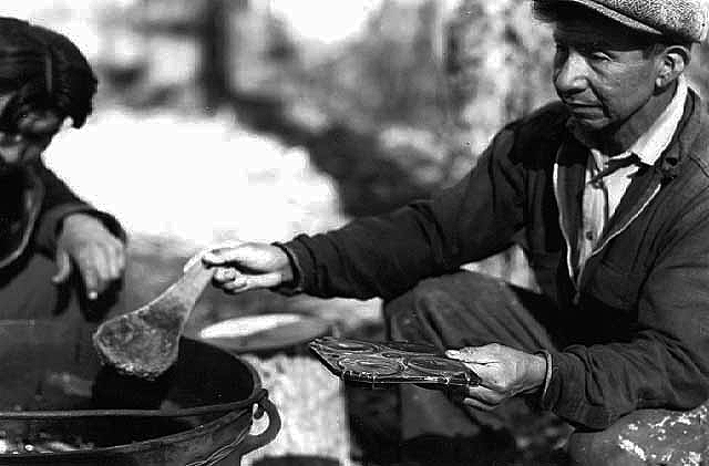 Martin Kegg pouring sugar into mold, Mille Lacs Indian Reservation, 1946.