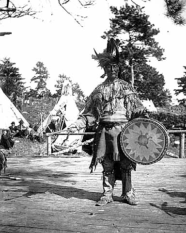 Chippewa medicine man singer with ceremonial turtle clan drum, ca. 1900.