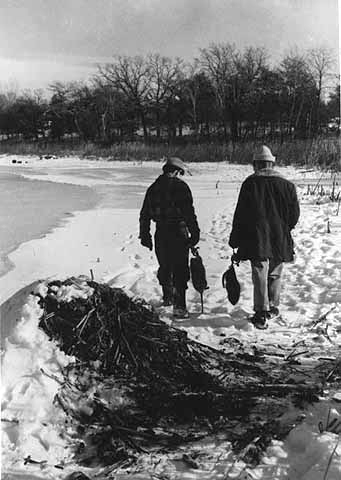 Men carrying two muskrats that they had trapped, ca. 1970.