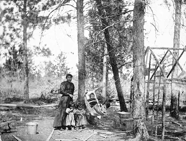 Chippewa Indian camp with Indian woman and children, 1900