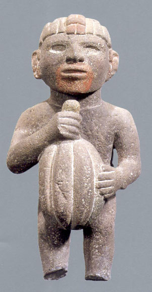 Aztec statuary of a male figure holding a cacao pod.