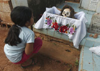 seven-year-old Maya Indian Litzy Moo pays homage to the bones of her grandmother on October 29, 2006.
