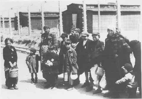 Children in front of barbed wire and barracks