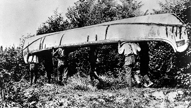 Men portaging a canoe, ca. 1880.