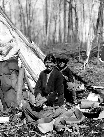 Mrs. Waboose (Wah Boose) and son, Jess, making birch bark containers for sap, 1925