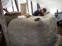 Pat applying second coat of plaster to outside of oven.