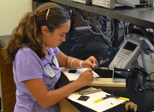 Middle school student with soldering iron.