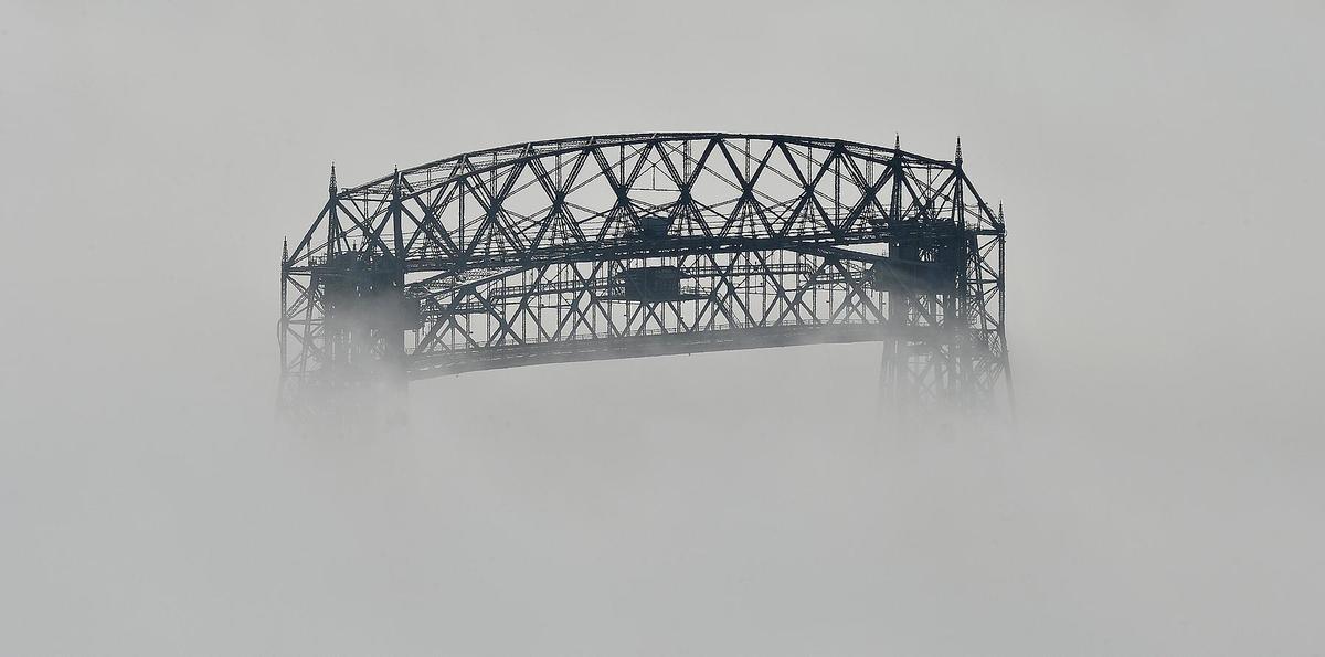 An aerial lift bridge partially obscured by fog.